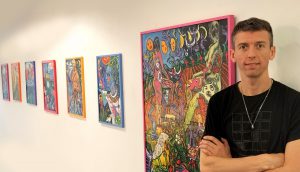 Rod alongside 4 pieces of his Blue Lotus exhibition on a white wall